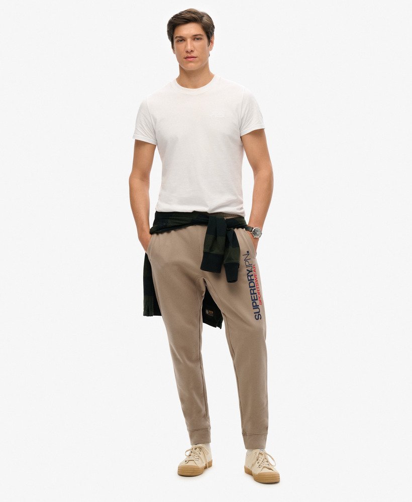 sportieve joggingbroek met logo en taps toelopende pijpen in diepbeige slubstof.